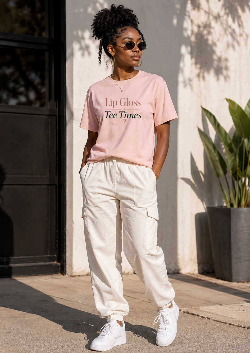 Woman wearing Lip Gloss & Tee Times women's golf tee with white pants