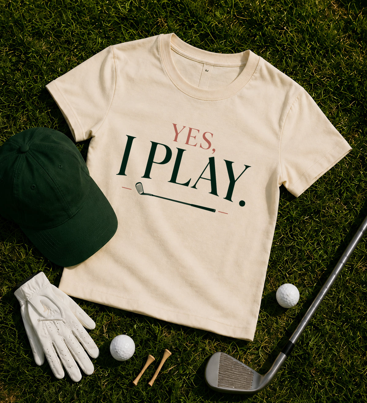 Yes. I Play. women's golf tee styled with green hat, golf ball, golf club and glove