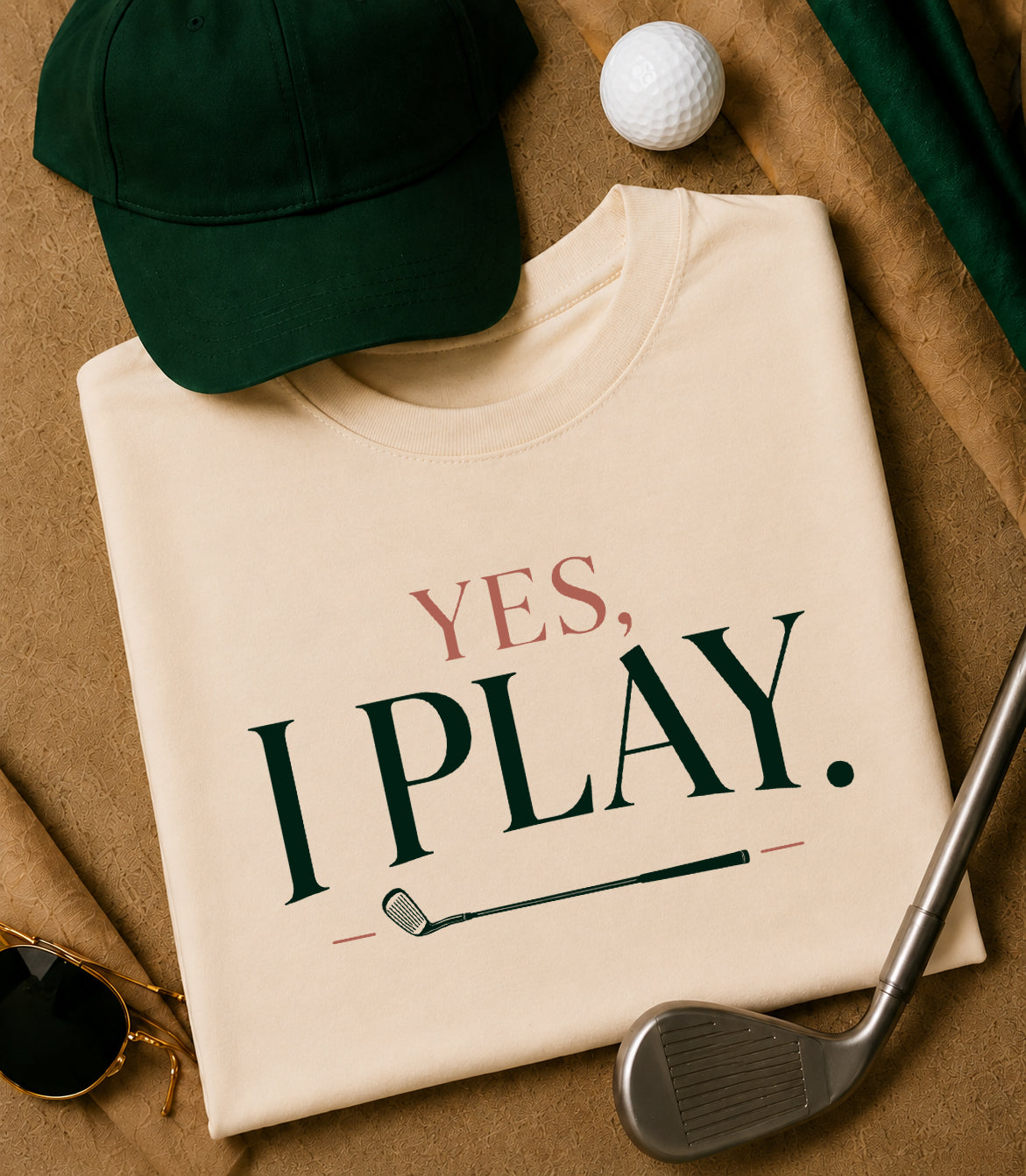 Yes. I Play. women's golf tee styled with green hat, golf ball, golf club , and sunglasses.